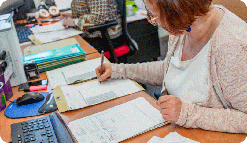 Une collaboratrice en train de vérifier les notes de frais pour le traitement comptable.